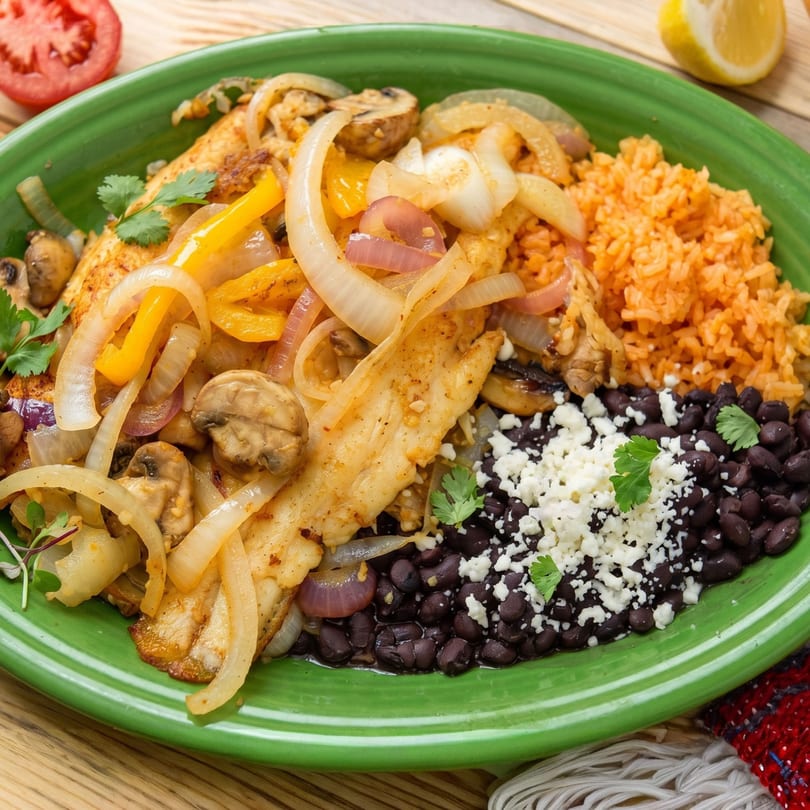 Chicken fajitas with sautéed onions, bell peppers, mushrooms, rice, and black beans with cheese.